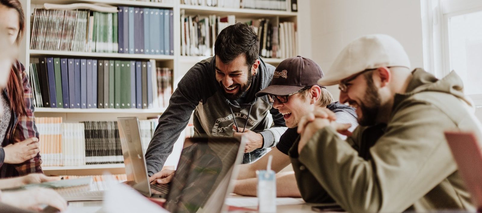 Foto von Priscilla Du Preez three men laughing while looking in the laptop inside room